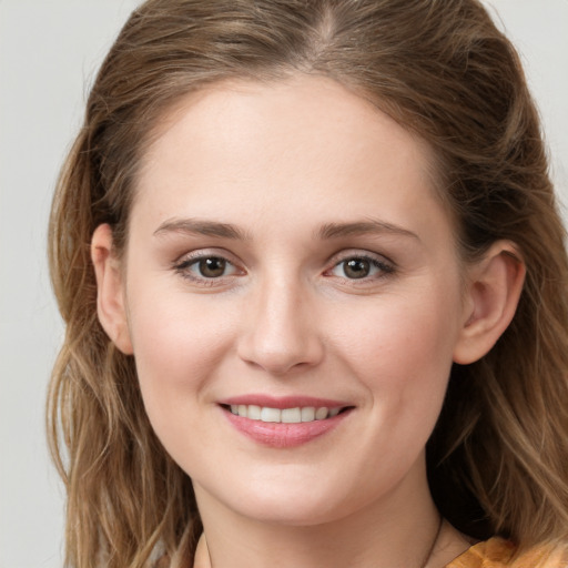 Joyful white young-adult female with long  brown hair and green eyes