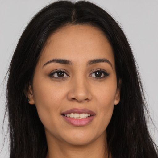 Joyful latino young-adult female with long  brown hair and brown eyes