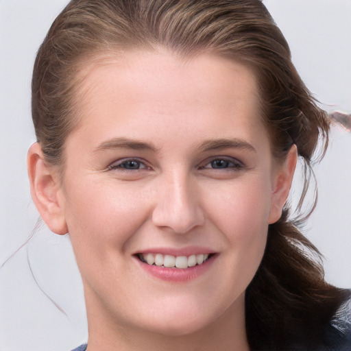 Joyful white young-adult female with long  brown hair and blue eyes