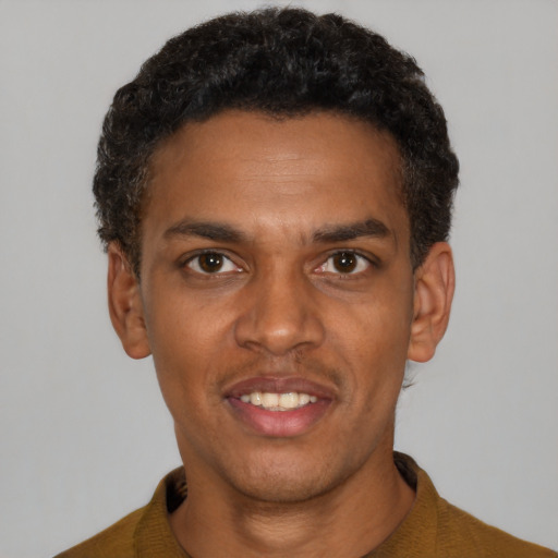 Joyful black young-adult male with short  black hair and brown eyes