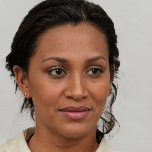 Joyful black adult female with medium  brown hair and brown eyes