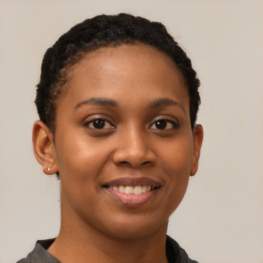 Joyful black young-adult female with short  black hair and brown eyes