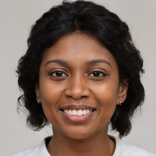Joyful black young-adult female with medium  black hair and brown eyes