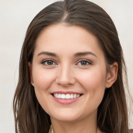 Joyful white young-adult female with long  brown hair and grey eyes