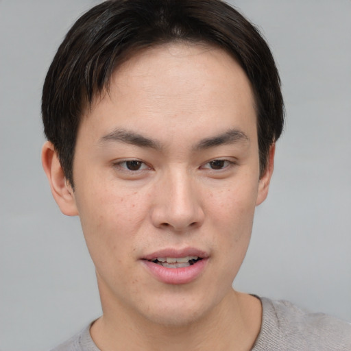 Joyful asian young-adult male with short  brown hair and brown eyes