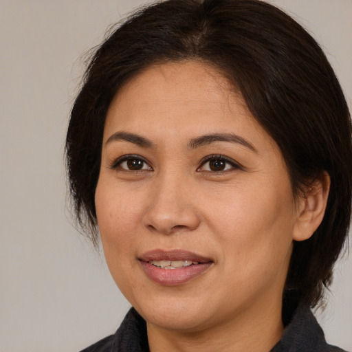 Joyful asian adult female with medium  brown hair and brown eyes