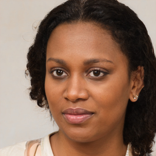 Joyful black young-adult female with medium  brown hair and brown eyes