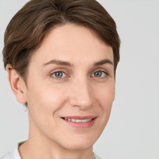 Joyful white young-adult female with short  brown hair and grey eyes