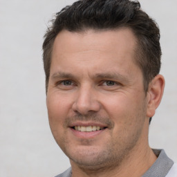 Joyful white adult male with short  brown hair and brown eyes