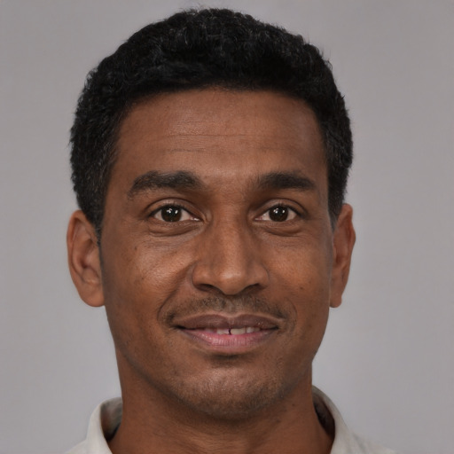 Joyful black adult male with short  black hair and brown eyes