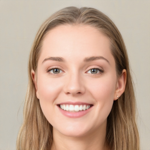 Joyful white young-adult female with long  brown hair and blue eyes