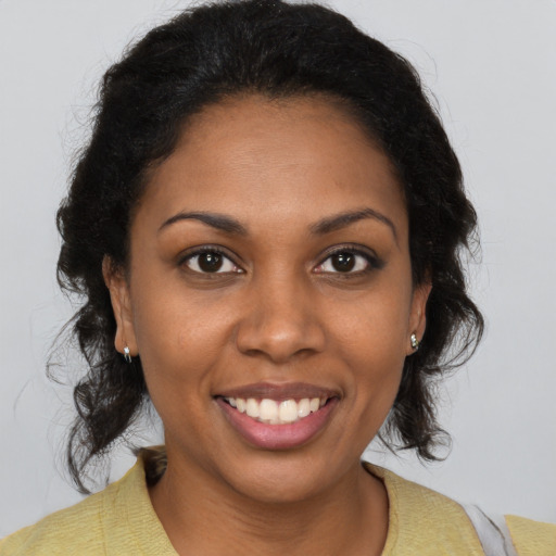 Joyful black young-adult female with medium  brown hair and brown eyes