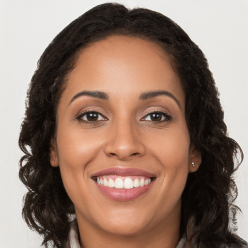 Joyful latino young-adult female with long  brown hair and brown eyes