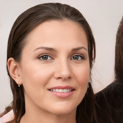 Joyful white young-adult female with long  brown hair and brown eyes