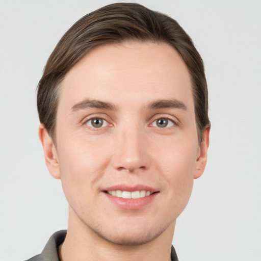 Joyful white young-adult male with short  brown hair and grey eyes