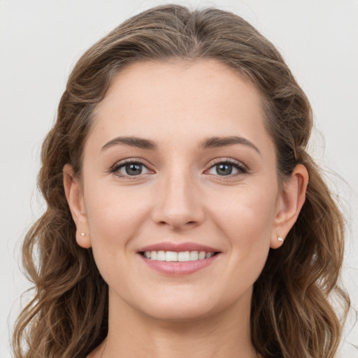 Joyful white young-adult female with long  brown hair and grey eyes