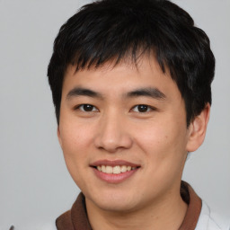 Joyful asian young-adult male with short  black hair and brown eyes