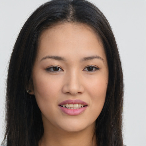 Joyful asian young-adult female with long  brown hair and brown eyes