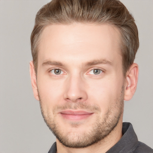 Joyful white young-adult male with short  brown hair and grey eyes