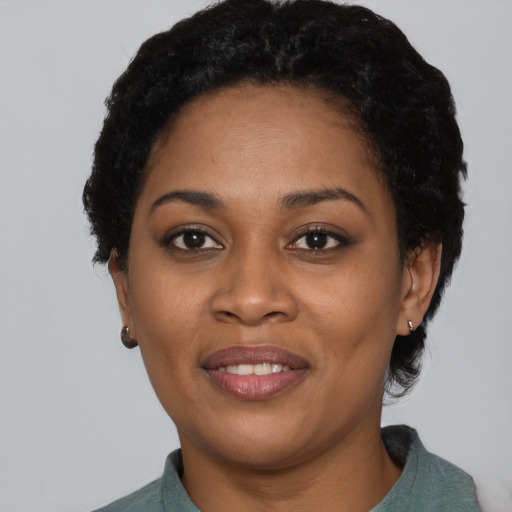 Joyful black adult female with short  black hair and brown eyes