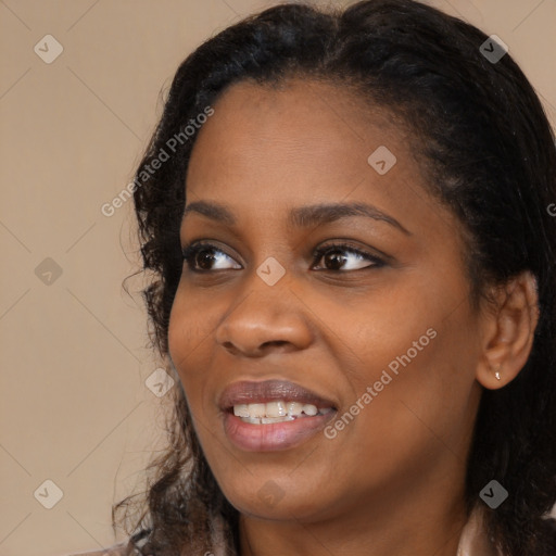 Joyful black young-adult female with long  black hair and brown eyes