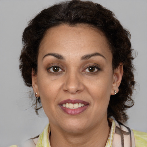 Joyful latino adult female with medium  brown hair and brown eyes