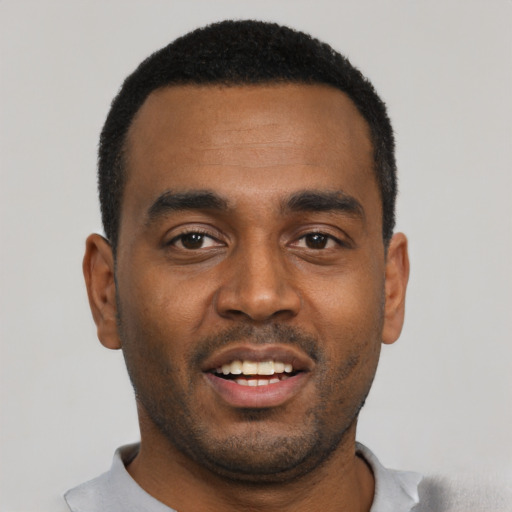 Joyful black young-adult male with short  black hair and brown eyes