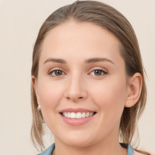 Joyful white young-adult female with medium  brown hair and grey eyes