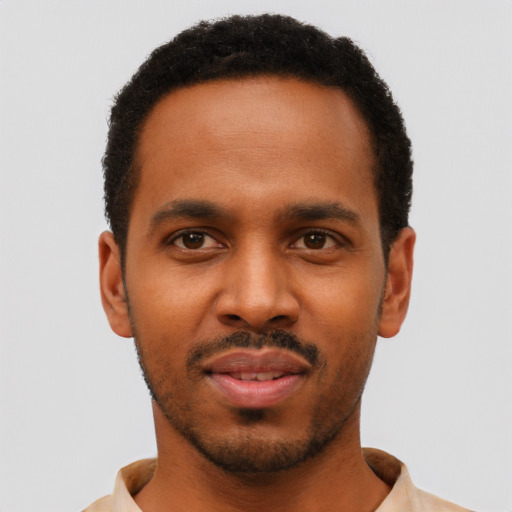 Joyful black young-adult male with short  black hair and brown eyes