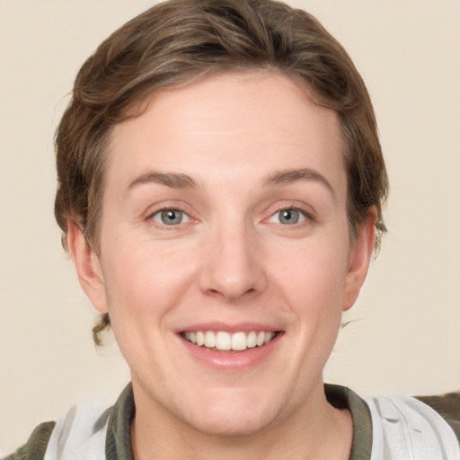 Joyful white young-adult female with short  brown hair and green eyes