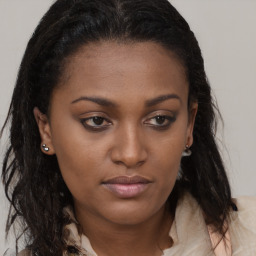 Joyful black young-adult female with long  brown hair and brown eyes