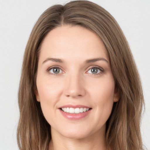 Joyful white young-adult female with long  brown hair and grey eyes