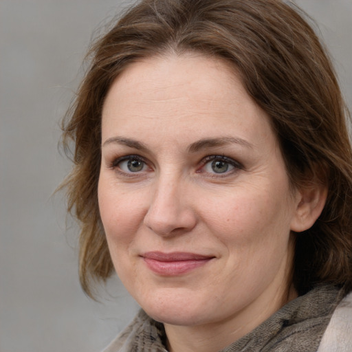 Joyful white adult female with medium  brown hair and grey eyes