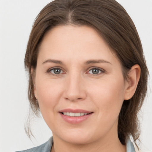 Joyful white young-adult female with medium  brown hair and grey eyes