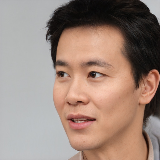 Joyful asian young-adult male with short  black hair and brown eyes