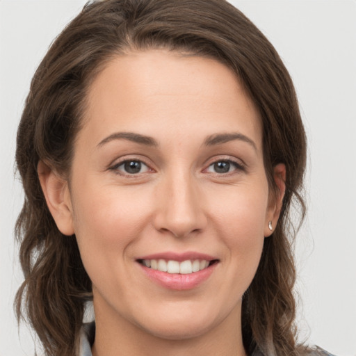 Joyful white young-adult female with long  brown hair and grey eyes