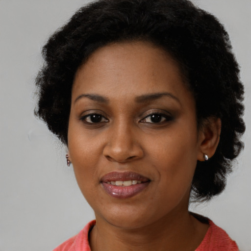 Joyful black young-adult female with short  brown hair and brown eyes