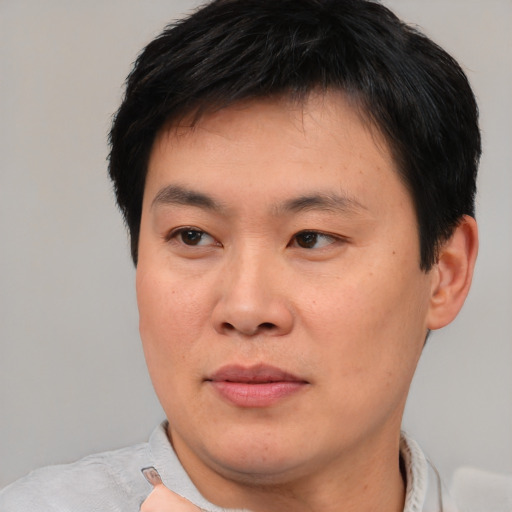 Joyful asian young-adult male with short  black hair and brown eyes