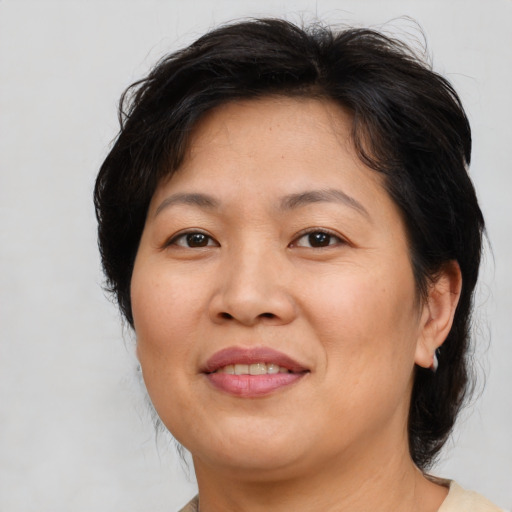 Joyful asian adult female with medium  brown hair and brown eyes
