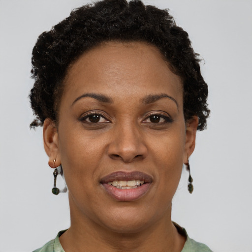 Joyful black adult female with short  brown hair and brown eyes