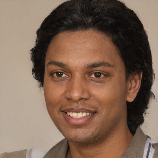 Joyful black young-adult male with short  brown hair and brown eyes