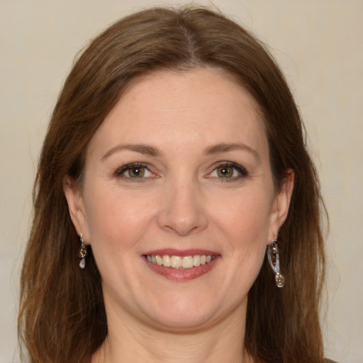 Joyful white young-adult female with long  brown hair and green eyes