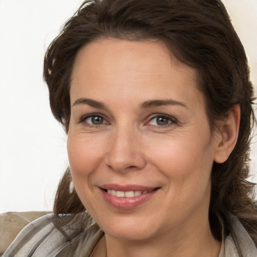 Joyful white adult female with long  brown hair and brown eyes