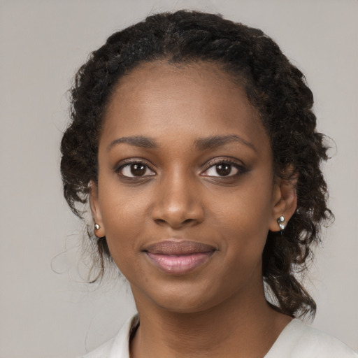 Joyful black young-adult female with medium  brown hair and brown eyes