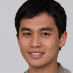 Joyful asian young-adult male with short  brown hair and brown eyes