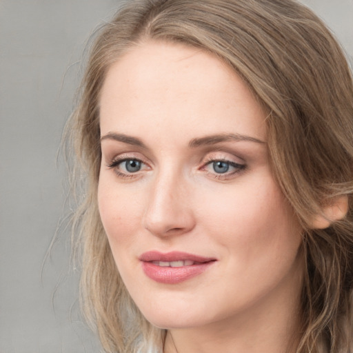 Joyful white young-adult female with long  brown hair and blue eyes