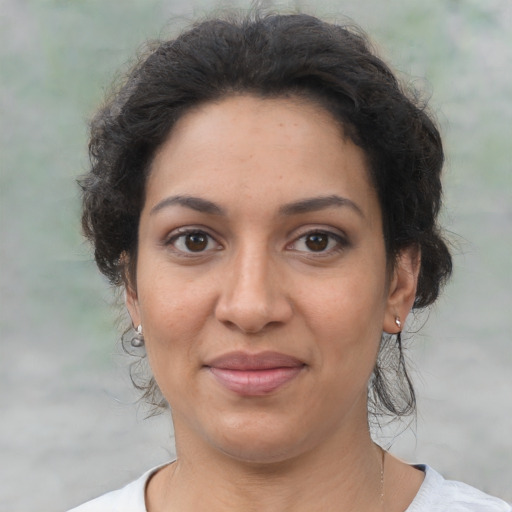 Joyful latino adult female with medium  brown hair and brown eyes