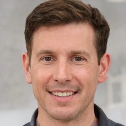 Joyful white adult male with short  brown hair and grey eyes