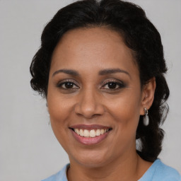 Joyful black adult female with medium  brown hair and brown eyes