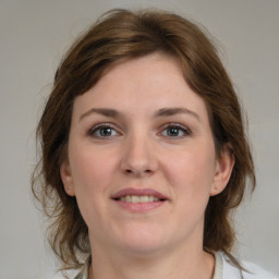 Joyful white young-adult female with medium  brown hair and grey eyes